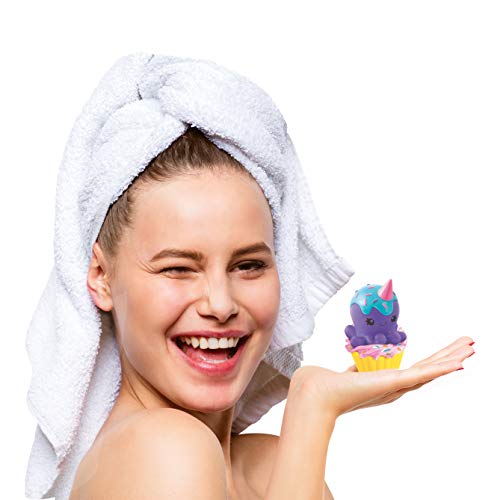 Child modeled by a child holding a colorful soap craft product with purple, blue, and yellow layers, wearing a white towel wrap
