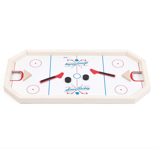 Smashockey tabletop game with white playing surface, red and blue markings, two red mallets with black handles, and three pucks in center