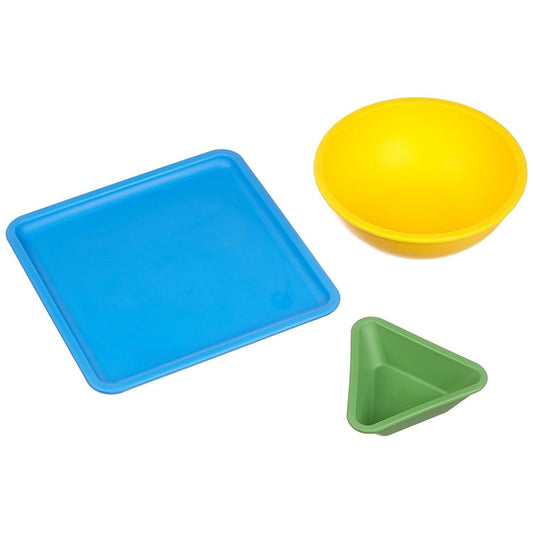 Three colorful plastic dishes: blue square tray, yellow round bowl, and green triangular bowl on plain background