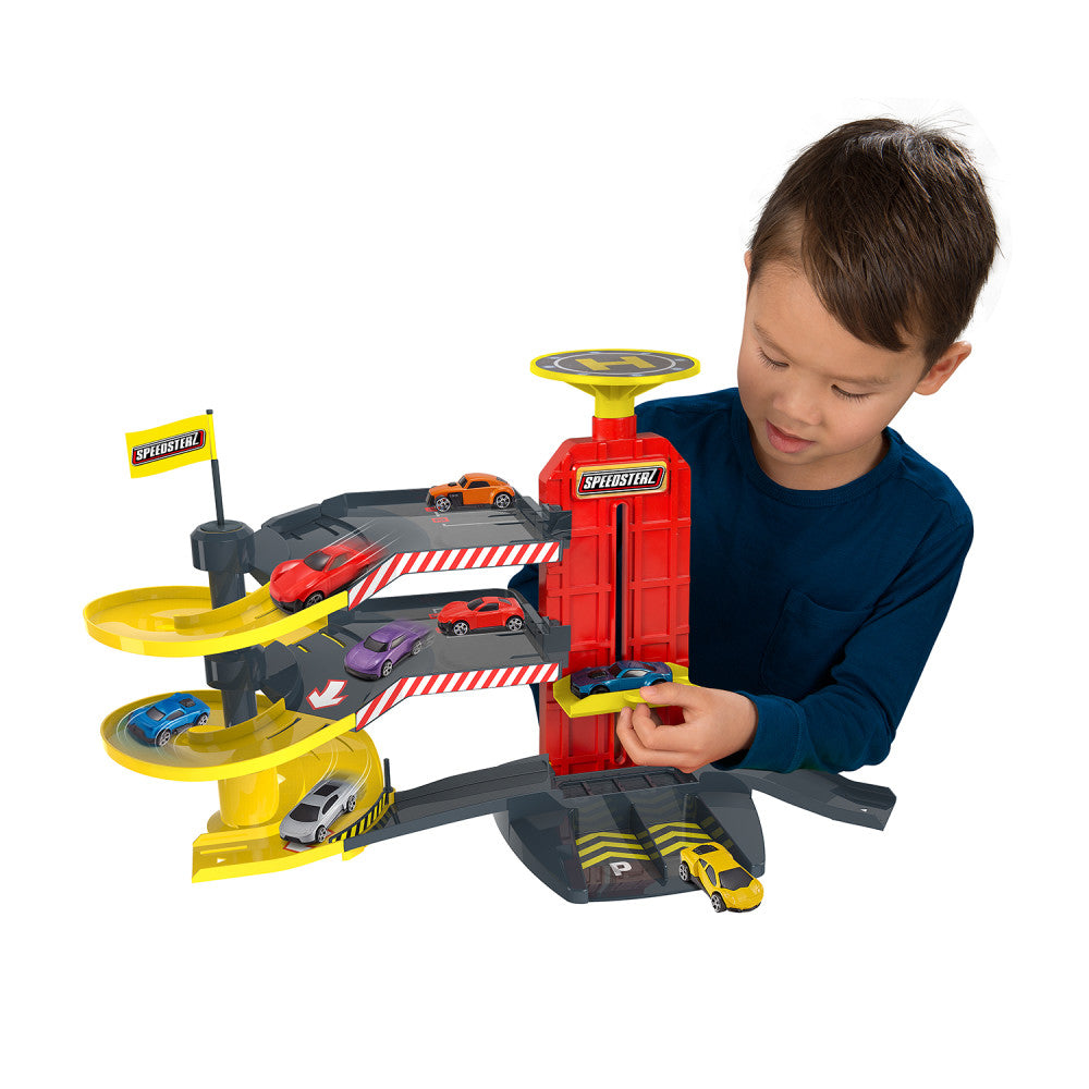Child modeled with Speedsterz 3-Level City Park & Drive Playset featuring yellow spiral ramps, red central tower, and five colorful die-cast cars on multiple le