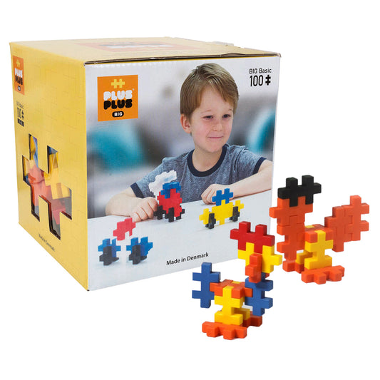 Plus-Plus Big building blocks in red, blue, yellow, and orange, modeled by a child constructing colorful 3D shapes; yellow box packaging shown
