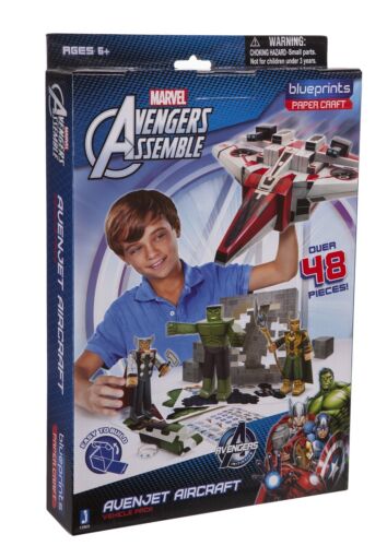 Avenjet Aircraft papercraft building set modeled by a child in blue shirt, showing assembled aircraft and building components on packaging box
