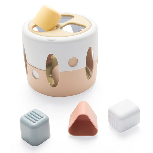 Beige and white cylindrical shape sorter toy with cutout holes and matching sorting pieces in blue, pink, and white