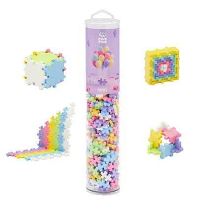 Plus-Plus Pastel 240-piece building set with cylindrical tube container and pastel-colored plastic blocks. Assembled examples show 3D cube, flat mosaic square,