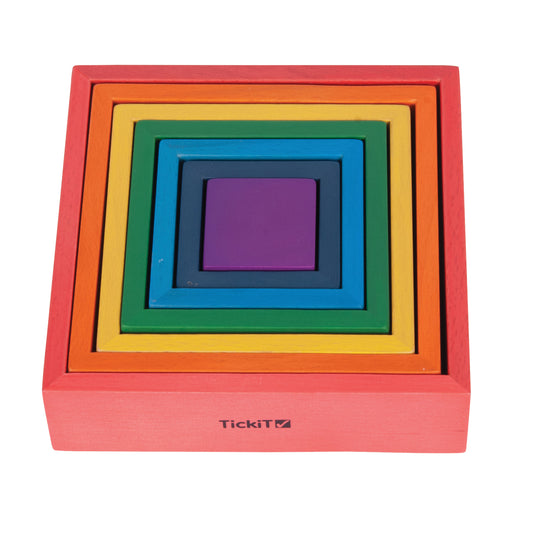 Seven nested wooden squares in rainbow colors: red, orange, yellow, green, blue, dark blue, and purple, stacked concentrically on plain background
