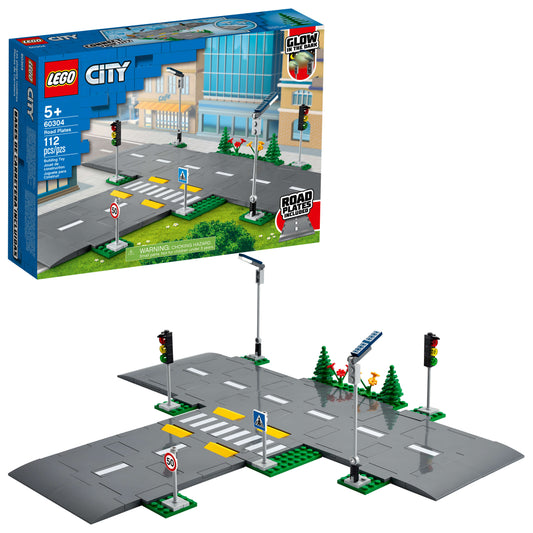 LEGO City Road Plates set showing gray road pieces with white lane markings, traffic lights, crosswalk, speed limit sign, and green base plates with trees and f