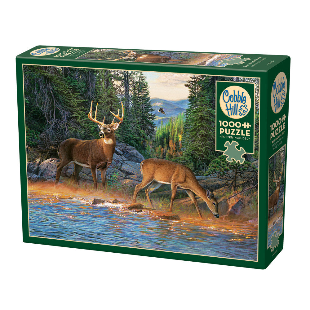 Cobble Hill 1000+ piece puzzle box featuring deer and doe drinking from a river in a forested landscape with mountains