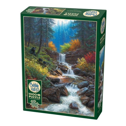 Cobble Hill 1000-piece jigsaw puzzle box featuring a forest waterfall landscape with cascading water, autumn foliage, evergreen trees, and bears on a mossy slop