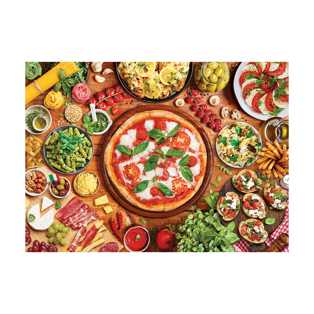 Overhead view of Italian food spread on wooden table with pizza, pasta, tomatoes, basil, cheese, cured meats, and fresh vegetables
