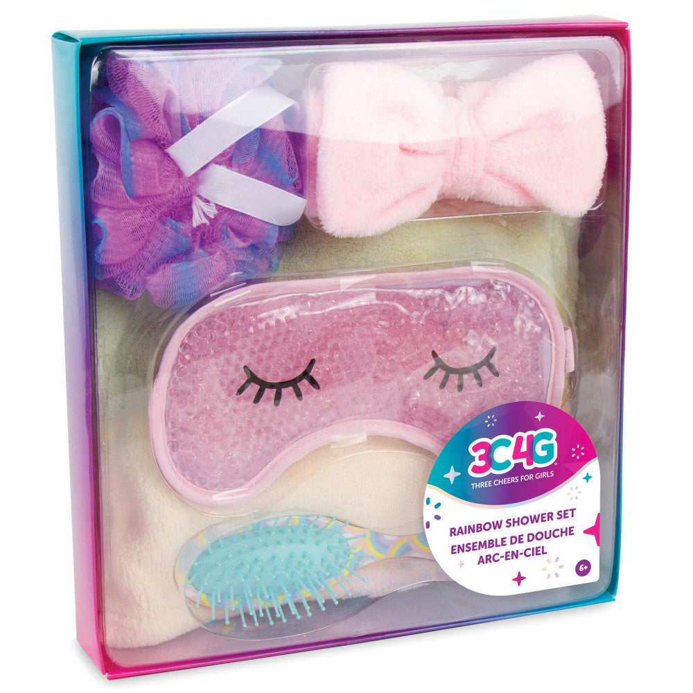 Three Cheers For Girls Rainbow Spa Shower Set with pink eye mask, fluffy hair bow, purple mesh pouf, and turquoise hair brush in rainbow packaging