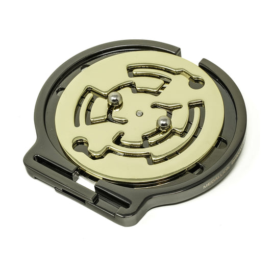 Hanayama Cast Medallion Puzzle, a circular metal maze puzzle with a cream-colored face and black metal frame, shown from above