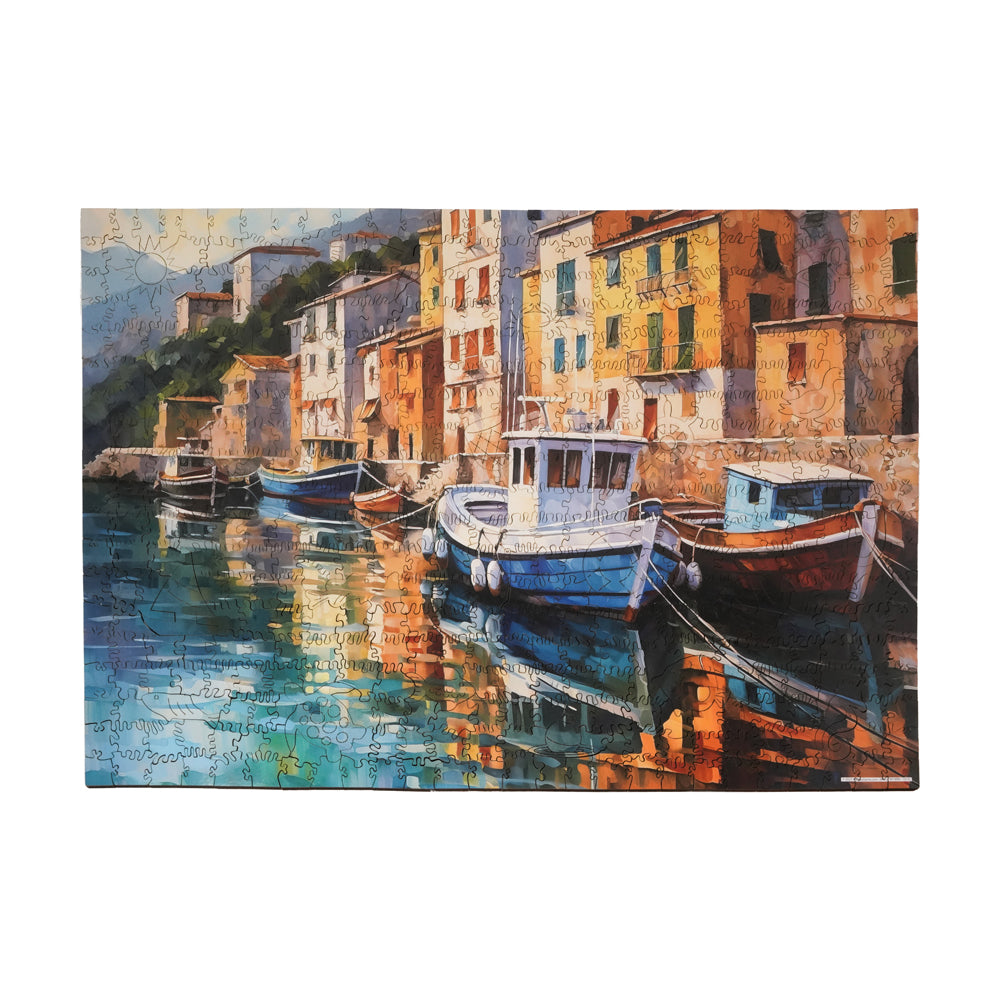 Wooden jigsaw puzzle showing colorful boats moored in a Mediterranean harbor with orange and yellow waterfront buildings reflected in turquoise water