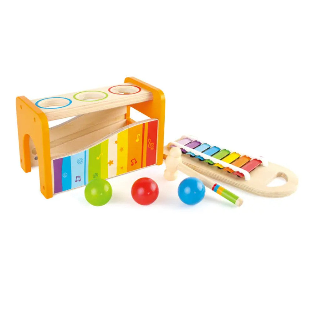 Hape Interactive Pound & Tap Bench with colorful xylophone keys, orange wooden frame, three balls, and slide-out xylophone on plain background