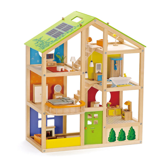 Three-story wooden dollhouse with green roof, natural wood frame, and colorful interior rooms including bedroom, bathroom, kitchen, and living spaces with minia