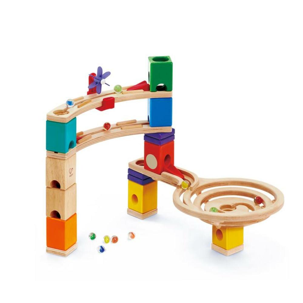 Hape Quadrilla wooden marble run with colorful stacked blocks, curved wooden tracks, and rolling balls on a plain white background