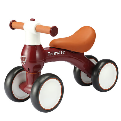 Trimate baby balance bike in wine red with tan saddle, cork handles, and black wheels with white centers