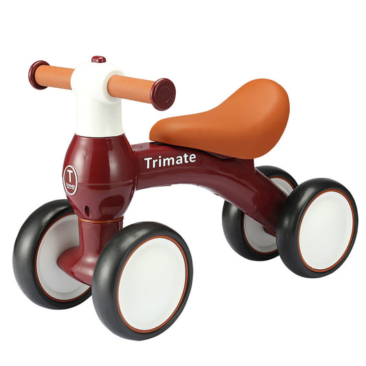 Trimate baby balance bike in wine red with tan saddle, cork handles, and black wheels with white centers