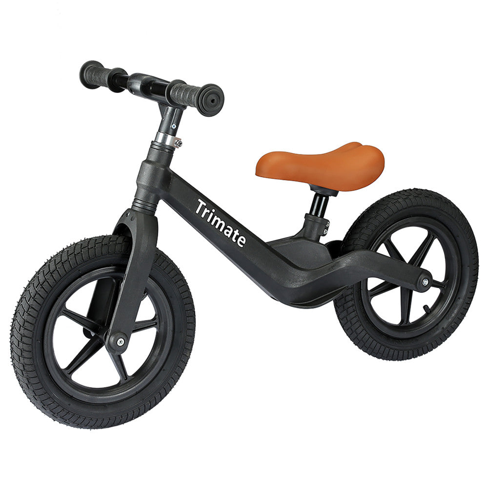 Black balance bike with brown saddle, textured handlebar grips, and black air-filled wheels on plain background