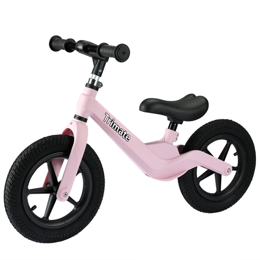 Pink balance bike with black handlebars, black saddle, and black pneumatic tires on plain background