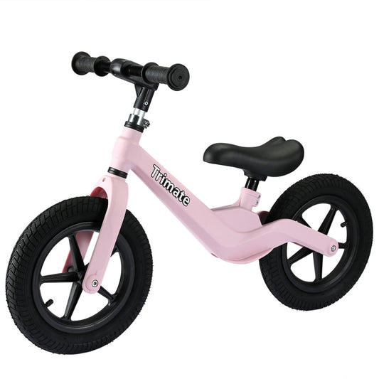 Pink balance bike with black handlebars, black saddle, and black pneumatic tires on plain background