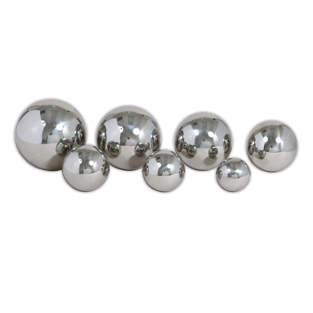 Set of 7 reflective silver metal balls in varying sizes arranged on a white background