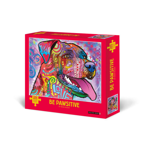 1000-piece jigsaw puzzle box with bright pink packaging featuring colorful pop art dog illustration with intricate patterned design by Dean Russo, titled Be Paw