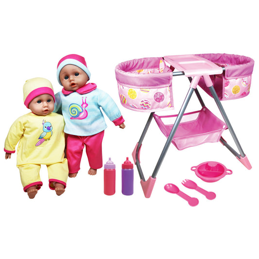 Two baby dolls in yellow and blue outfits with pink accents, pink folding playset with bassinet and storage, two bottles, plate, and feeding utensils