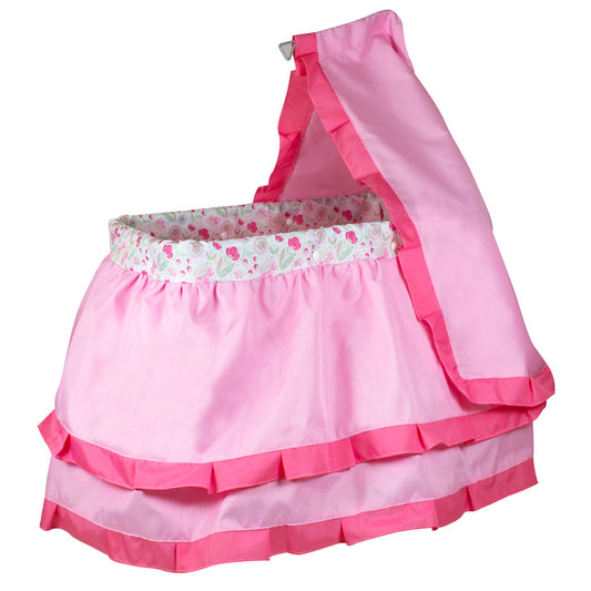 Pink doll bed with tiered ruffled skirt, floral patterned headboard trim, and matching canopy top on metal frame