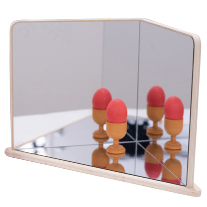 Wooden 4-way mirror with natural frame showing reflections of red and tan egg-shaped objects on mirrored surface