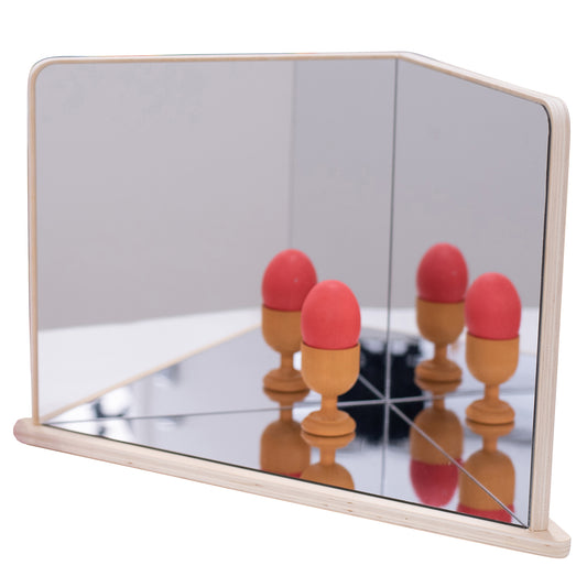 Wooden 4-way mirror with natural frame showing reflections of red and tan egg-shaped objects on mirrored surface