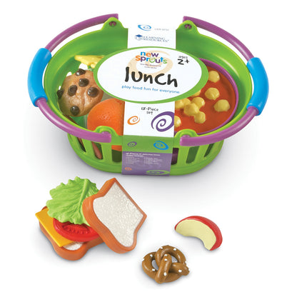 New Sprouts Lunch basket playset with green basket, purple and blue handles containing play food pieces including a chocolate chip cookie, orange, yellow corn,