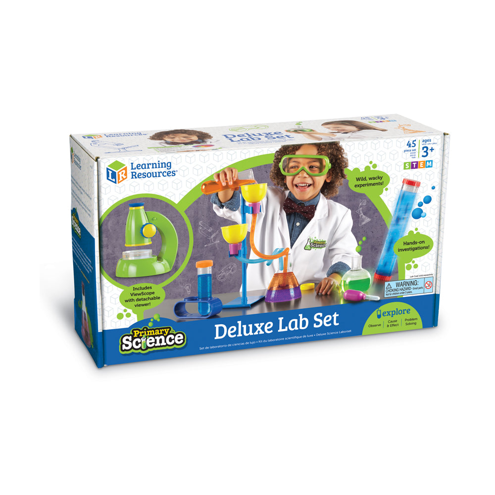 Primary Science Deluxe Lab Set box showing child modeled wearing green glasses and white lab coat, conducting experiments with colorful beakers, test tubes, and