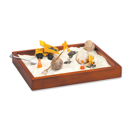 Wooden sandbox with sand, yellow construction vehicles, orange traffic cones, rocks, and miniature tools for tabletop play