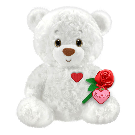 White plush teddy bear with brown nose, red heart on chest, holding a red rose and pink heart charm reading 'Be Mine'