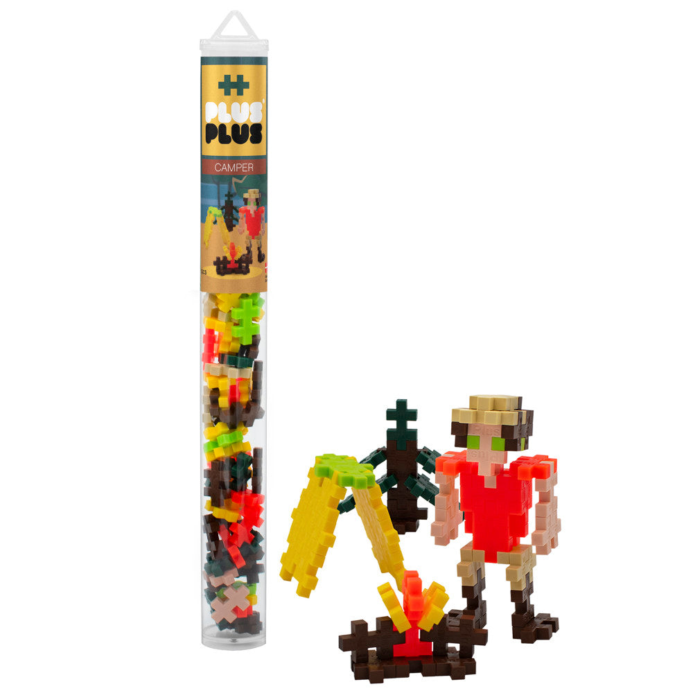 Plus-Plus Mini Camper Set building blocks in sealed tube with assembled pixel-style camper scene featuring tent, campfire, and figures