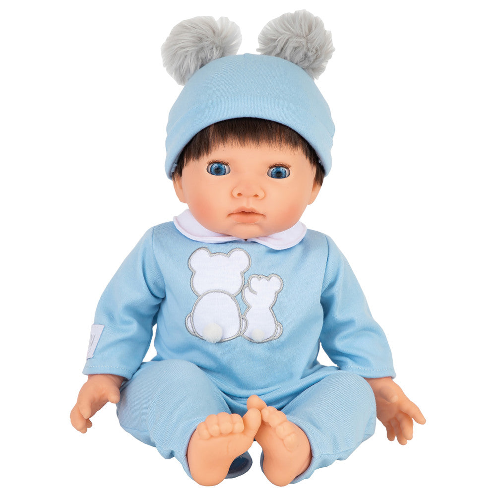 Baby doll with blue eyes wearing light blue outfit with bear design, matching blue knit hat with gray pom-pom ears