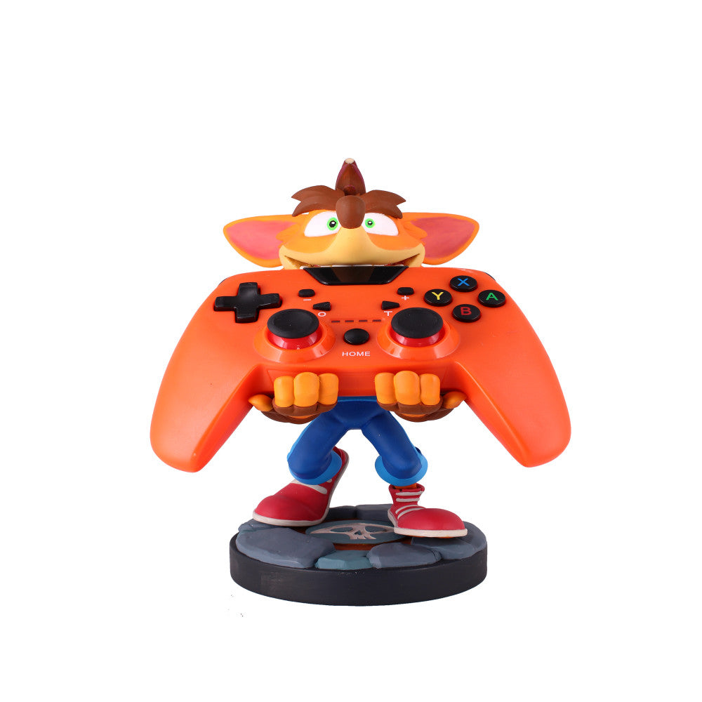 Crash Bandicoot character figure with orange controller body, brown head with spiky hair, green eyes, blue pants, red shoes, holding black gaming controller but