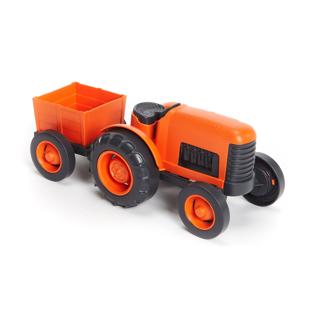 Orange toy tractor with black grille and tires, attached to a detachable orange cargo cart