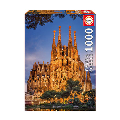 Educa 1000-piece jigsaw puzzle box featuring illuminated Sagrada Familia basilica at dusk with water reflection and trees