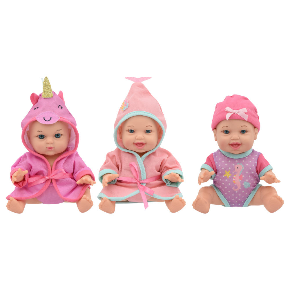 Three small baby dolls with interchangeable outfits: left doll wears pink unicorn hoodie with gold horn, center doll in pink robe with turquoise trim, right dol