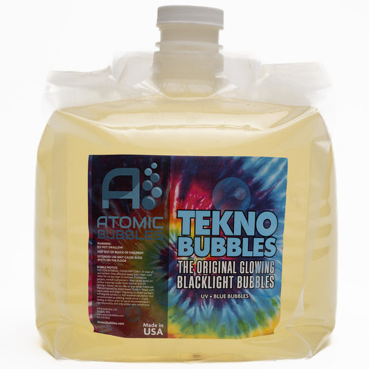 Large clear plastic jug of Tekno Bubbles UV glowing bubble refill solution in yellow liquid with gray cap and colorful tie-dye label