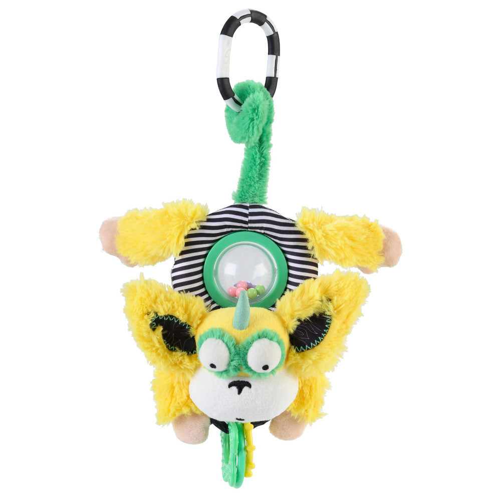 Yellow plush monkey with green horn, white face, and black eyes hanging from black and white striped ring with green fuzzy cord and interactive sensory details