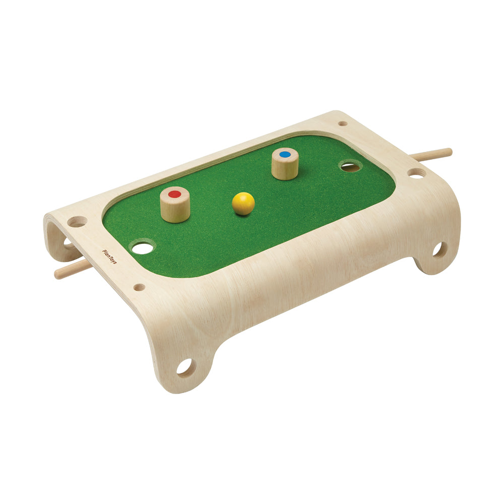 Wooden magnetic board game with green felt playing surface, two wooden pegs with colored tops, yellow ball, and holes for gameplay on plain background