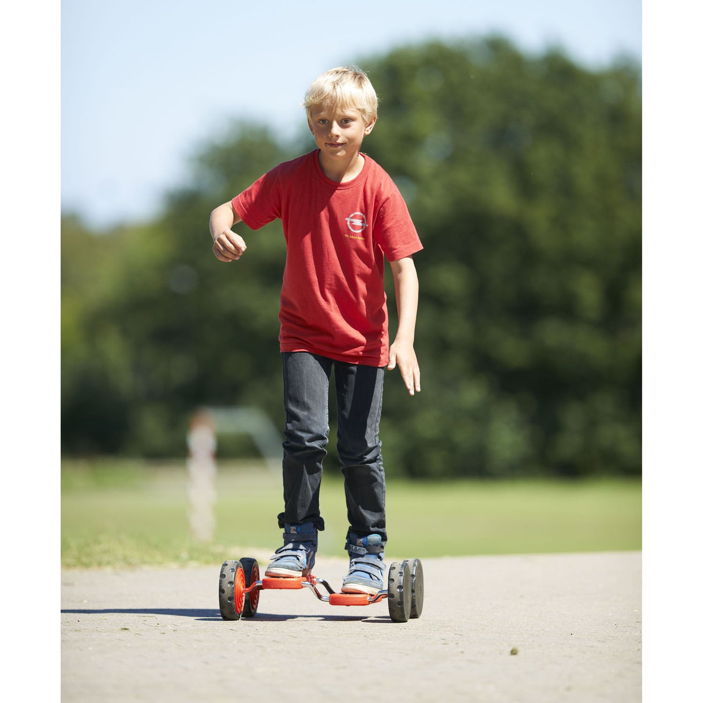 Child riding red and orange GONGE Go Go Roller on pavement outdoors