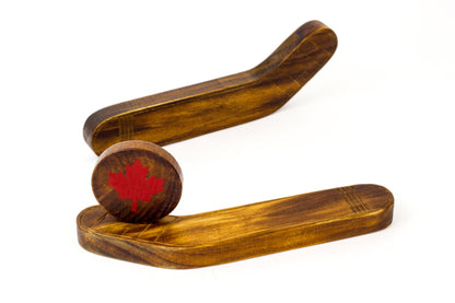 Wooden table hockey game with two wooden strikers and a ball painted with red maple leaf