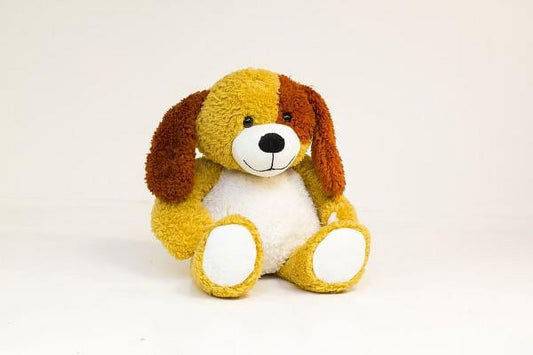 Yellow and brown plush dog with floppy ears, white muzzle and paw pads, sitting against plain background