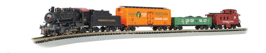 Black steam locomotive with Pennsylvania tender, orange Tropicana Orange Juice freight car, green Lehigh Valley car, and red Pennsylvania caboose on model train