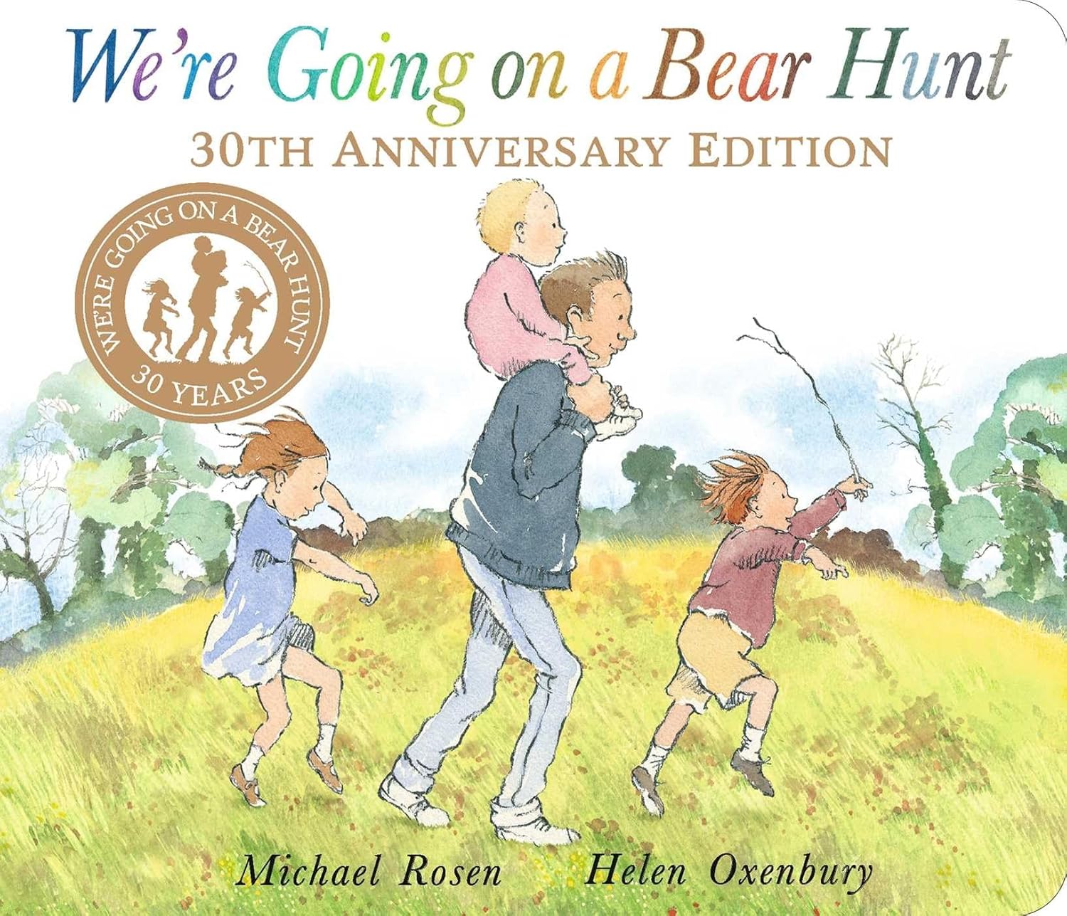 We're Going on a Bear Hunt 30th Anniversary Edition book cover showing an adult and three children running through a grassy field with trees, illustrated by Hel