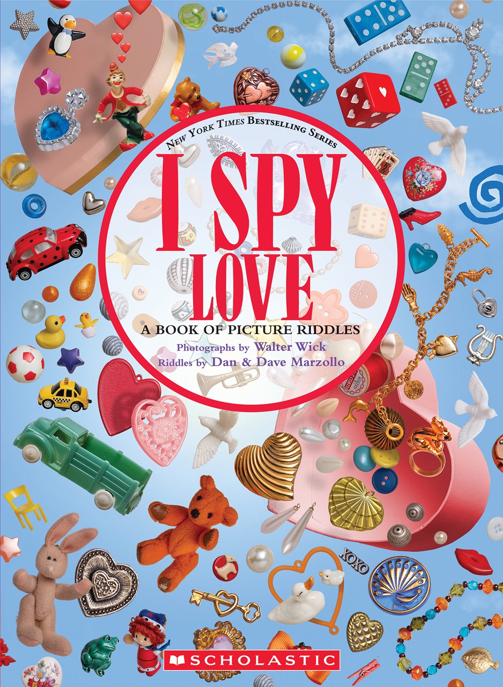 I Spy Love book cover featuring colorful objects including hearts, toys, dice, jewelry, and trinkets arranged on a blue background with pink heart shapes