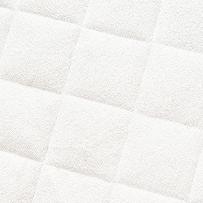 Close-up of quilted bamboo mattress protector showing white padded fabric with diagonal quilting pattern
